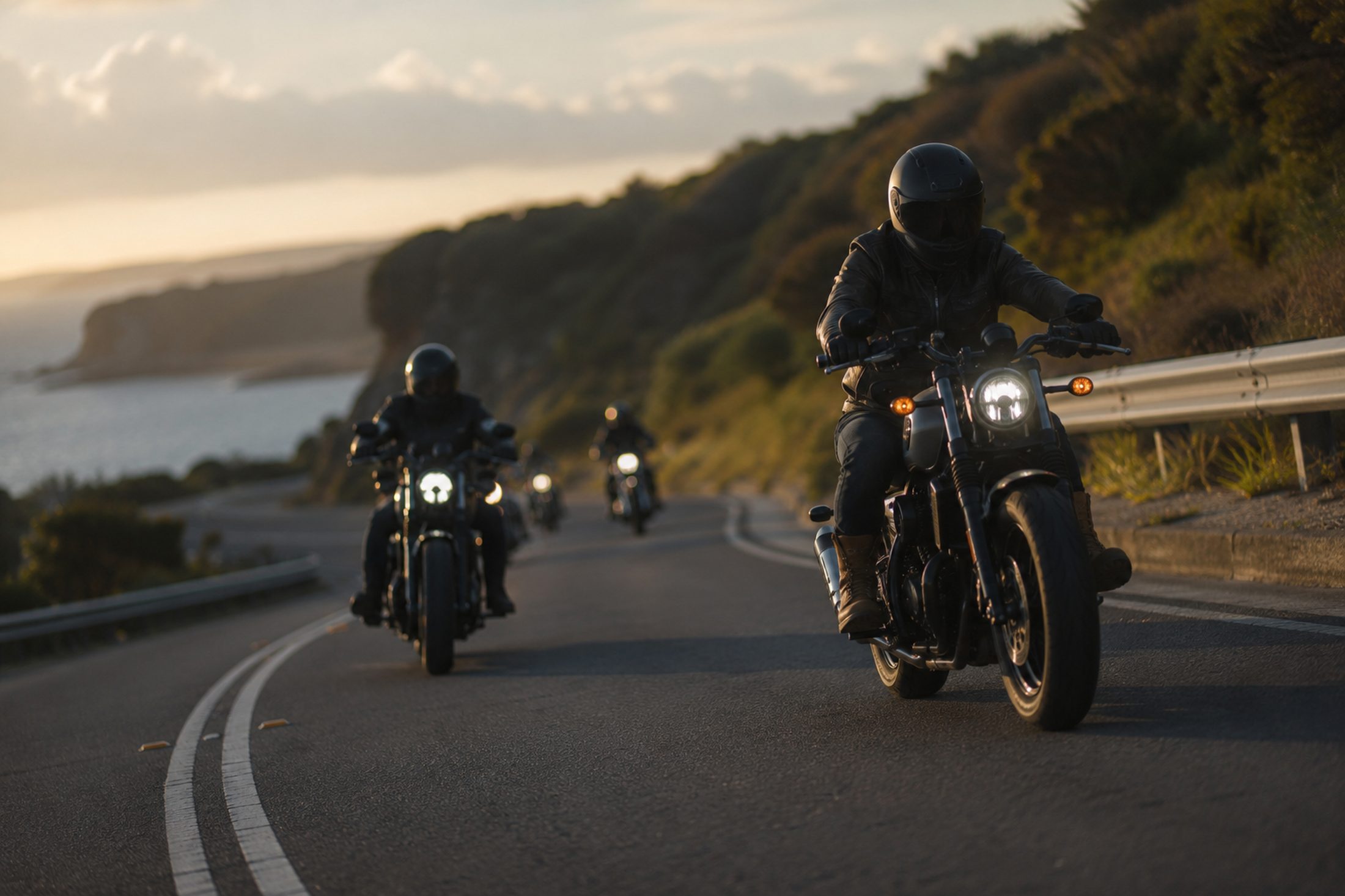A group of riders leaning through a coastal bend at sunset on an Australian road.
